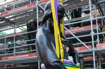 A worker looks on June 23, 2025, as a statue of St. Paul, the first of the 16 now-renovated statues that adorn the roof of Notre Dame Cathedral in Paris, is lifted by a crane, marking the last phase of reconstruction of the cathedral's roof, damaged by the April 2019 fire.