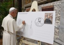 Pope Leo XIV signs a facsimile of an envelope with an enlarged copy of the Vatican post office's special stamp and cancellation marking the 500th anniversary of the birth of composer Giovanni Pierluigi da Palestrina during an event in the Sala Regia of the Vatican's Apostolic Palace June 19, 2025.