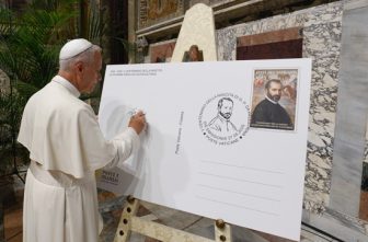 Pope Leo XIV signs a facsimile of an envelope with an enlarged copy of the Vatican post office's special stamp and cancellation marking the 500th anniversary of the birth of composer Giovanni Pierluigi da Palestrina during an event in the Sala Regia of the Vatican's Apostolic Palace June 19, 2025.