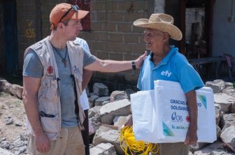 John Service, senior technical adviser for humanitarian operations at Catholic Relief Services, talks with Porfirio Espinoza Felipe, 93, after giving him an emergency shelter tarp in front of his house that was destroyed after a 2017 earthquake in Huamuchil, Mexico.