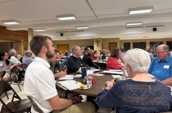 In foreground, Adam Eberhard of Transfiguration in Oakdale listens during an evening of reflection for those who will participate in the Archdiocesan Synod 2025 Be My Witnesses Assembly June 7 at Cretin-Derham Hall in St. Paul.