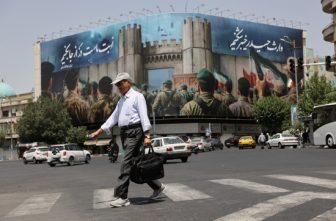 A man walks next to an anti-Israeli billboard on a street, during early hours of ceasefire, in Tehran, Iran, June 24, 2025. President Donald Trump announced on social media June 23 that Israel and Iran reached a ceasefire agreement after 12 days of war, however both sides accused the other of violations in the hours afterward.