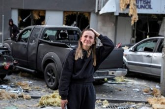 A woman reacts near a building housing the local branch of the British Council, as she stands at the site of an apartment building hit during Russian missile and drone strikes in Kyiv, Aug. 28, 2025.