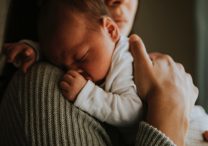 Mother holding sleeping child soft light