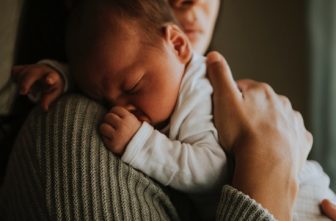 Mother holding sleeping child soft light